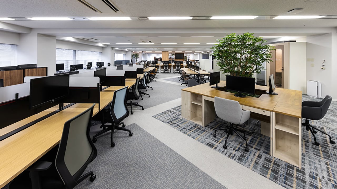 オフィスコム東京本社・市ヶ谷ライブショールーム。木目調の内装とグリーンを取り入れたオフィス空間