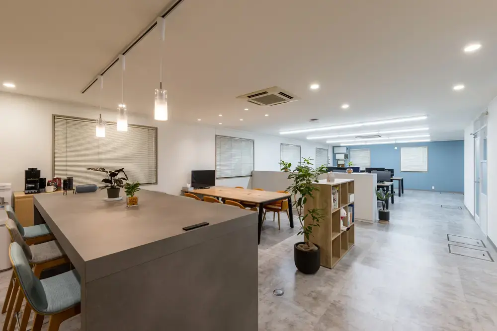 約60坪 フリーアドレスとカウンターを備えたカフェ風オフィス全体。ラウンジと執務エリアを一体的に配置した交流空間